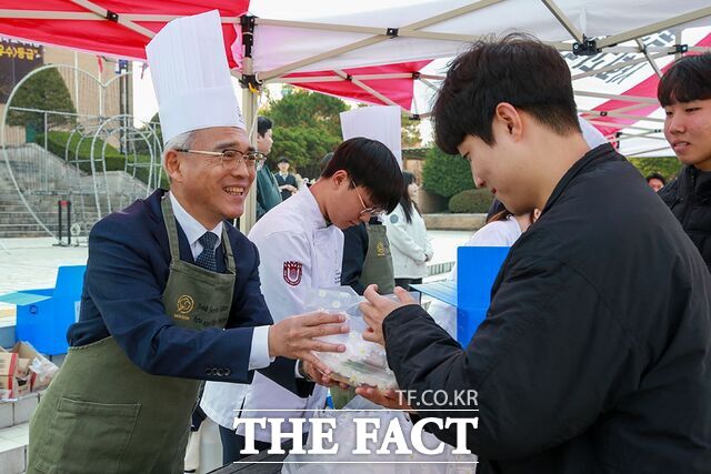 24일 정오 목원대 중앙도서관 앞 진리의광장에서 이희학 총장(왼쪽)이 한 학생에게 간식 꾸러미를 전달하고 있다. /목원대