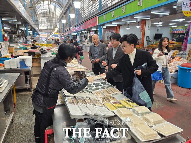 김겸 여수시소상공인연합회 회장과 송병구 여수시도시관리공단 이사장이 26일 진남시장에서 전통시장 장보기 캠페인을 진행하고 있다. /여수시소상공인연합회