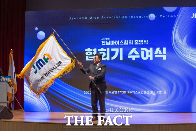 임규성 전남마이스협회 초대 회장이 27일 여수엑스포컨벤션센터 그랜드홀에서 열린 협회 출범식에서 협회기를 힘차게 흔들고 있다. /전남마이스협회