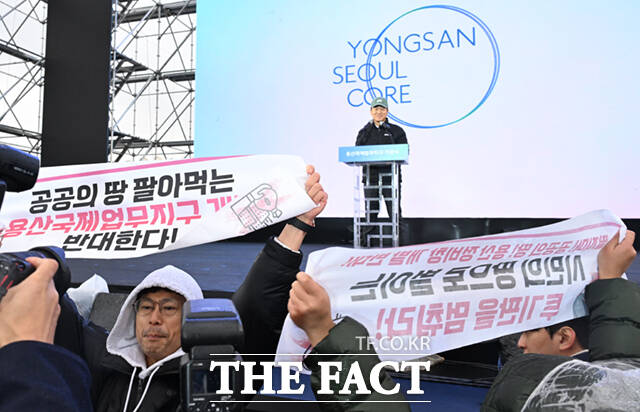 27일 오후 서울 용산구 정비창 내 야외 행사장에서 열린 용산국제업무지구 도시개발사업 기공식에서 오세훈 서울시장이 비전 발표를 앞둔 가운데, 주거·빈곤·노동·시민사회단체들로 구성된 용산정비창 개발의 공공성 강화를 위한 공동대책위원회(용산정비창 공대위) 회원들이 개발 계획 철회를 촉구하는 기습시위를 하고 있다. /이새롬 기자