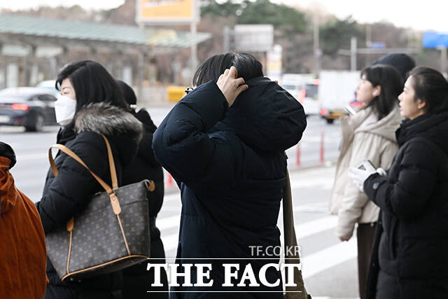 한 시민이 추위로 붉어진 손을 따뜻한 음료로 녹이고 있다.