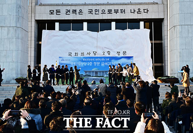 우원식 국회의장을 비롯한 참석자들이 3일 오후 서울 여의도 국회 2층 정문 글새김 제막식에 참석해 가림막을 제거하고 있다. /국회=배정한 기자