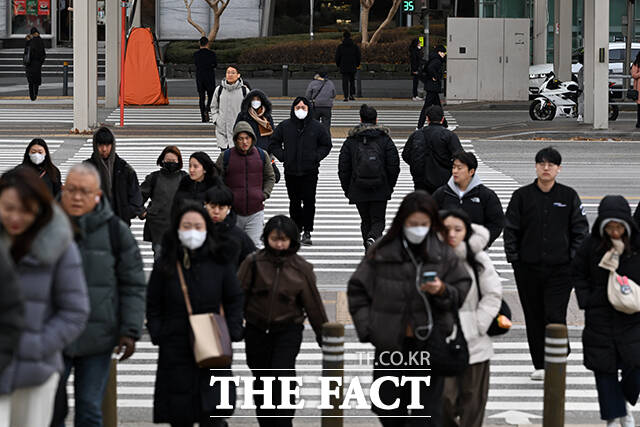 한 시민이 추위로 붉어진 손을 따뜻한 음료로 녹이고 있다.
