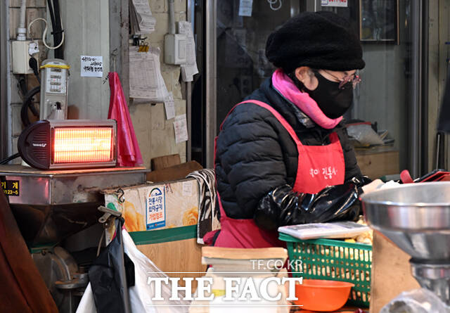 또 다른 상인이 난로를 쬐며 가게를 지키고 있다.