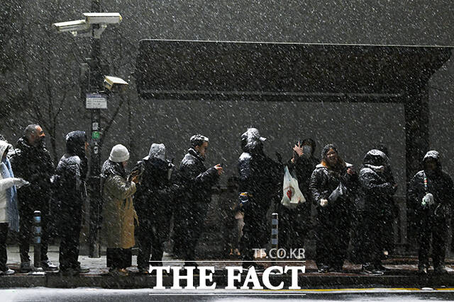 시민들이 눈을 맞으며 버스를 기다리고 있다. /서예원 기자