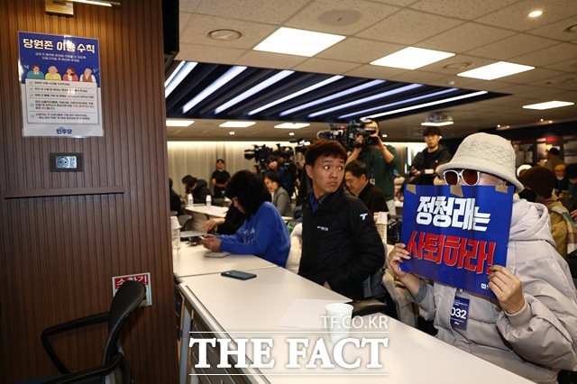 지난 1일 오후 서울 여의도 더불어민주당사 당원존에서 열린 '당원 주권 정당 실현을 위한 제도개선 토론회'에서 한 당원이 정청래 대표의 사퇴를 촉구하는 손피켓을 들고 있다. /뉴시스