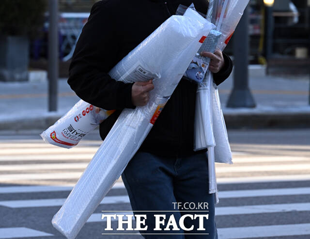 한 시민이 단열시트 꾸러미를 든 채 이동하고 있다.