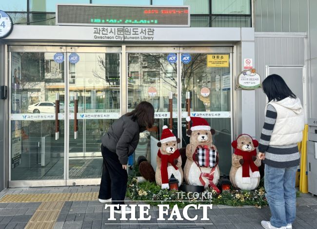 시민들이 문원도서관에 장식된 크리스마스 소품을 바라보고 있다. /과천시