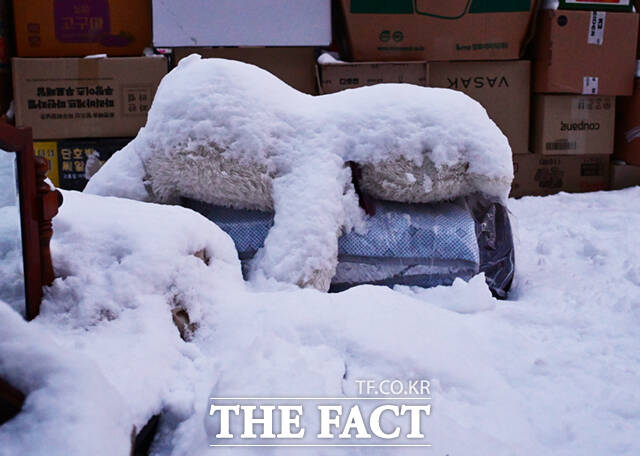 아파트 단지 내 버려진 인형 위에 전날 내린 눈이 쌓여 있다.