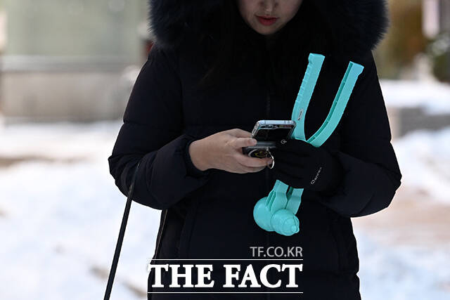 한 시민이 눈오리 집게를 들고 출근길 발걸음을 옮기고 있다.