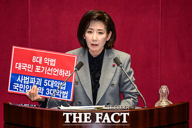 나경원 국민의힘 의원이 9일 오후 서울 여의도 국회에서 열린 본회의에서 가맹사업거래의 공정화에 관한 법률 일부개정법률안에 대한 무제한 토론에 나서며 8대 악법 대국민 포기선언하라 라고 적힌 손팻말을 들고 있다. /국회=남윤호 기자