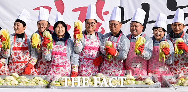 우원식 국회의장과 국회의원들이 김장 배추를 들고 기념촬영하고 있다.