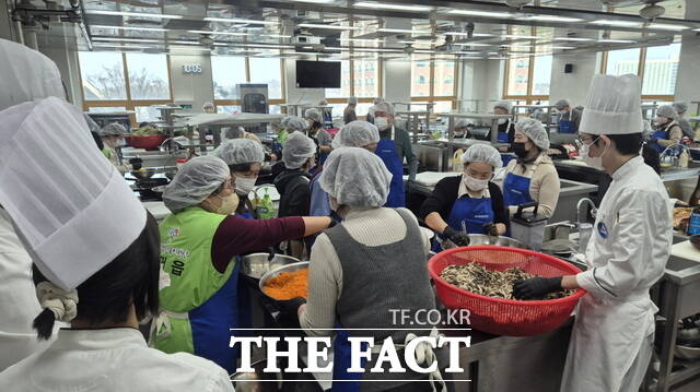 천안시가 11일 백석문화대학교에서 행복키움지원단 취약계층 꾸러미 나눔 전달식을 개최했다. 반찬 꾸러미를 만들고 있는 모습. /천안시