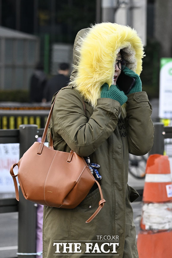서울 종로구 광화문 인근에서 한 시민이 모자를 깊이 눌러쓰고 있다.