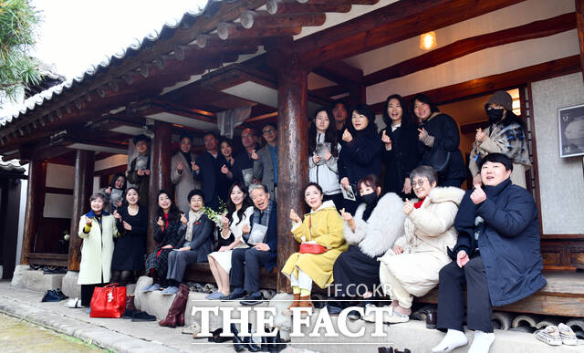 김효지 작가와 김온정 큐레이터를 비롯한 참석자들이 13일 여수 원도심 낭만배울학교 쉬어家에서 열린 김효지 개인전 우주를, 바다를-담다, 닮다 개막식 후 기념 촬영을 하고 있다. /고병채 기자