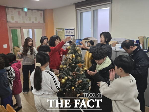 금산다락원 직원들이 사랑호크마지역아동센터 아동들과 크리스마스트리를 만들고 있다. /금산군