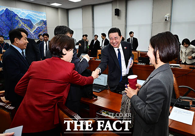 김병기 운영위원장(가운데)이 18일 오전 서울 여의도 국회에서 열린 운영위원회 전체회의에 참석해 야당 의원들과 밝은 표정으로 인사를 하고 있다. /국회=배정한 기자