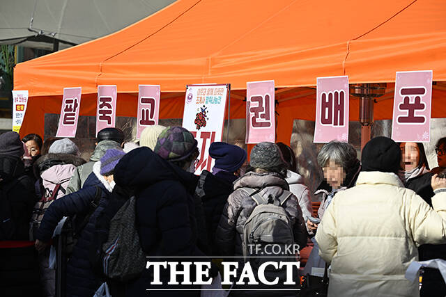 연중 밤이 가장 길고 낮이 가장 짧은 '동지'인 22일 오전 서울 종로구 조계사를 찾은 방문객들이 팥죽 교환권을 받고 있다. /송호영 기자