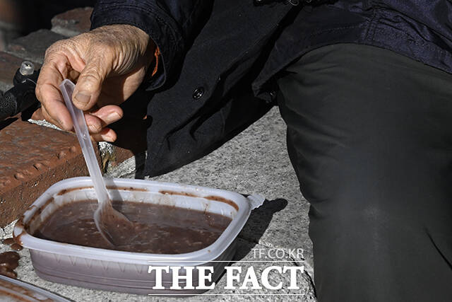 22일 오전 서울 종로구 조계사를 찾은 방문객들이 팥죽을 먹고 있다.