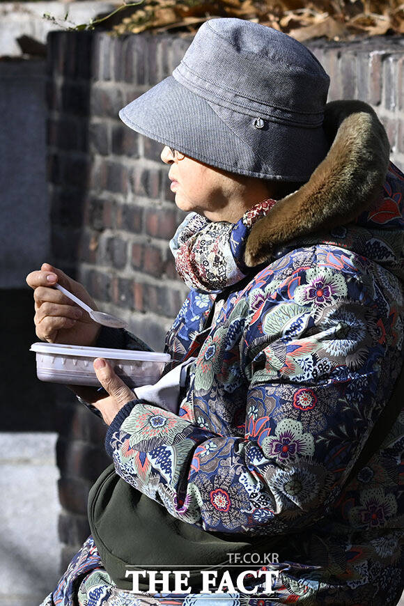 22일 오전 서울 종로구 조계사를 찾은 방문객들이 팥죽을 먹고 있다.