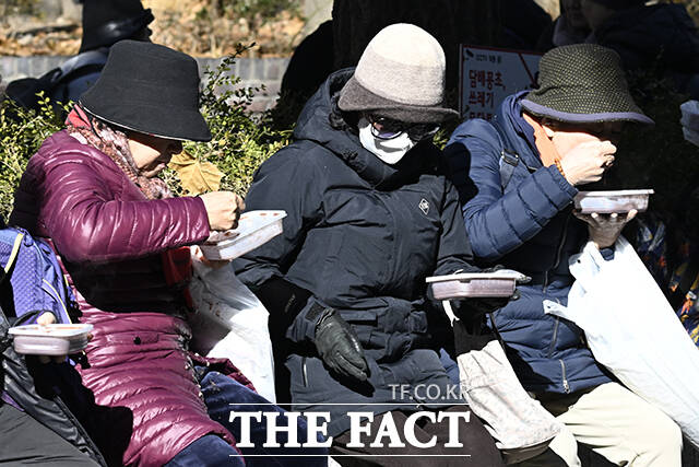 22일 오전 서울 종로구 조계사를 찾은 방문객들이 팥죽을 먹고 있다.