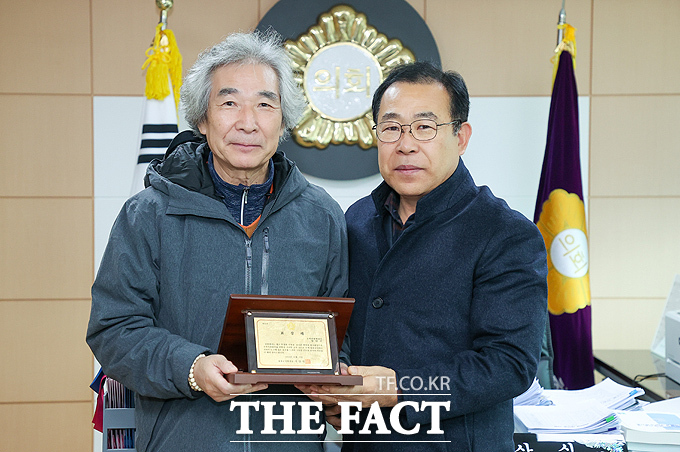 이상식 울릉군의회 의장(오른쪽)이 울릉 관광·문화 홍보 및 활성화에 기여한 임만주 문화관광해설사에게 표창패를 수여하고 있다. /울릉군의회