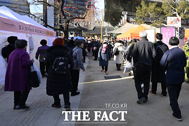 22일 오전 서울 종로구 조계사를 찾은 방문객들이 팥죽을 먹고 있다.