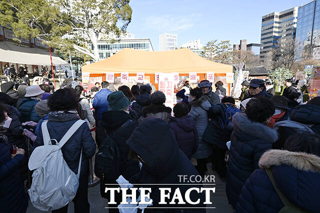 22일 오전 서울 종로구 조계사를 찾은 방문객들이 팥죽을 먹고 있다.