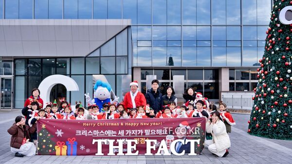 김정겸 충남대학교 총장이 23일 성탄절을 앞두고 도서관 앞 크리스마스트리 앞에서 충남대어린이집 원아에게 성탄 선물을 전달했다. /충남대학교