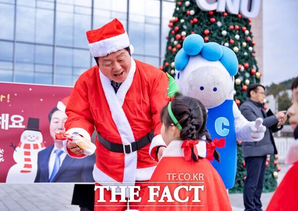 김정겸 충남대학교 총장이 23일 성탄절을 앞두고 도서관 앞 크리스마스트리 앞에서 충남대어린이집 원아에게 성탄 선물을 전달했다. /충남대학교