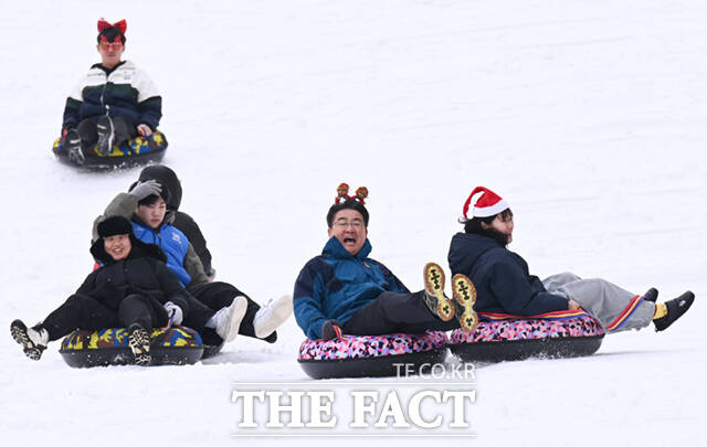 노원구가 23일 서울 노원구 서울과학기술대학교 종합운동장에서 '씽씽 눈썰매장'을 개장한 가운데, 오승록 구청장이 아이들과 눈썰매를 타고 있다.