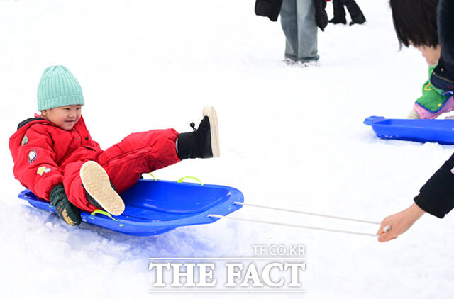노원구가 23일 서울 노원구 서울과학기술대학교 종합운동장에서 '씽씽 눈썰매장'을 개장한 가운데, 오승록 구청장이 아이들과 눈썰매를 타고 있다.
