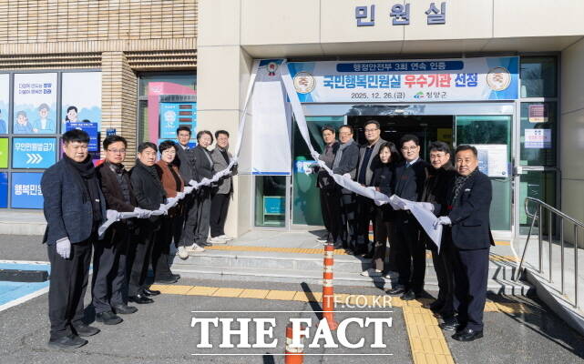 26일 청양군이 군청 민원실 앞에서 김돈곤 군수와 김기준 청양군의회 의장을 비롯해 공무원 20여 명이 참석한 가운데 국민행복민원실 인증 기념 현판 제막식이 열리고 있다. /청양군