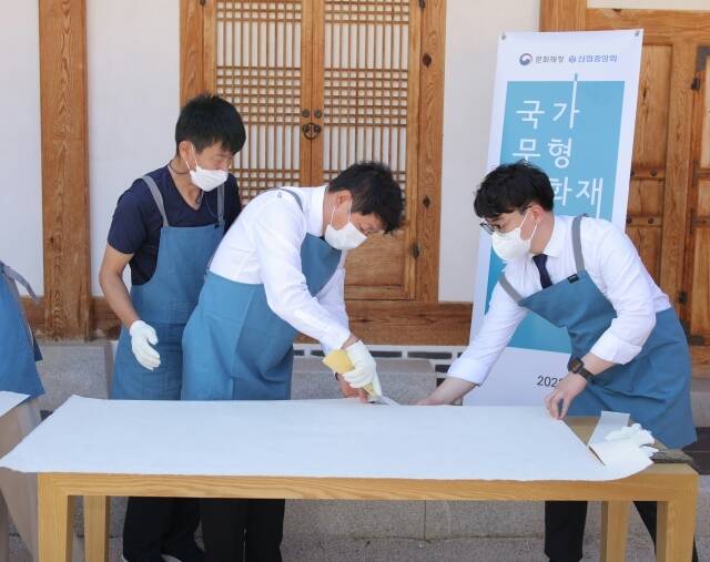 김윤식 신협중앙회장(왼쪽 두번째)과 전주한지협동조합 관계자가 전통 제조방식으로 한지를 제작하고 있다. /신협중앙회