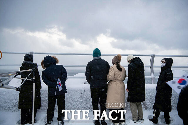 해맞이 행사애 참여한 가족단위 주민들이 강한 눈보라로 일출을 보지못했지만 저마다의 소원을 빌고 있다. /울릉군