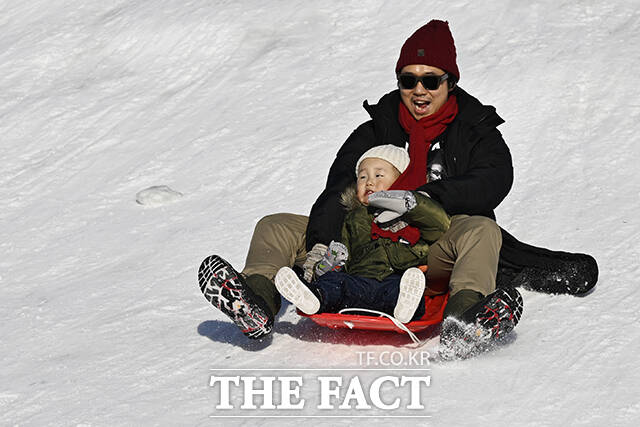 눈썰매를 타고 있는 어린이.