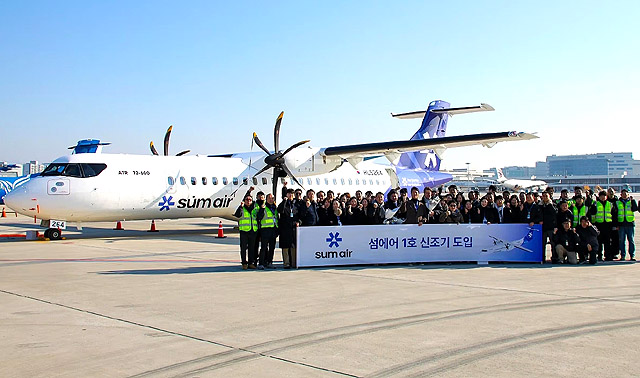 김포공항에 도착한 섬에어 1호기 앞에서 섬에어 전직원이 기념 촬영을 하고 있다. /