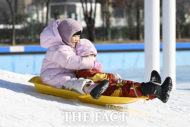 눈썰매를 타고 있는 어린이.