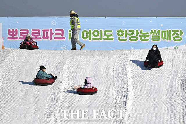 눈썰매를 타고 있는 어린이.