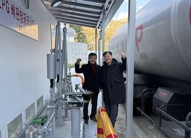 울릉군이 LPG 배관망 구축 사업 추진 5년 만에 첫 가스 충전을 시작했다. 남한권 울릉군수(왼쪽)와 가스설비업자가 기념사진을 찍고 있다. /울릉군
