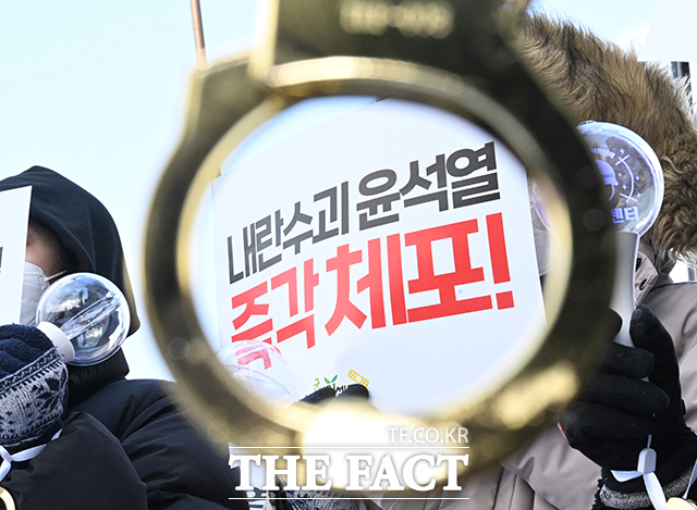 내란수괴 윤석열 시민체포단 깁급행동 집회가 지난해 12월 21일 오전 서울 용산구 대통령 관저 앞에서 열린 가운데 참가자가 피켓을 들고 있다./박헌우