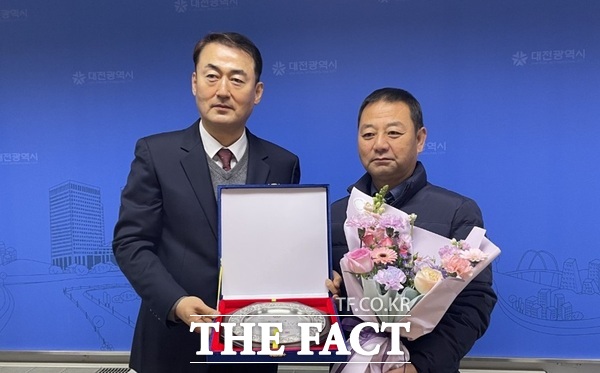 남시덕 대전시 교통국장(왼쪽)이 협진운수 김홍균 기사(오른쪽)에게 7일 버스킹(BUS-KING) 표창패를 수여했다. /대전시