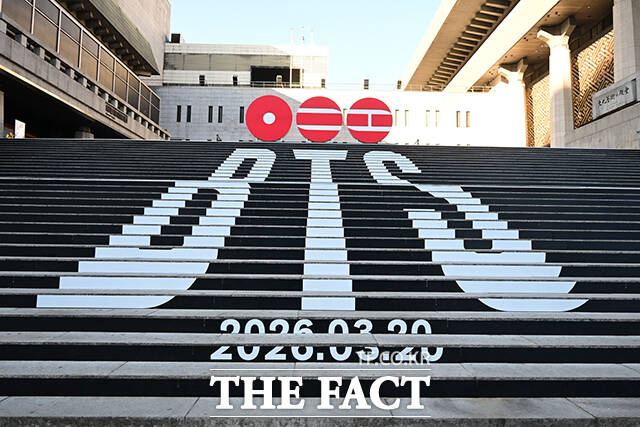 방탄소년단(BTS)의 5집 로고 조형물 살펴보는 관광객.