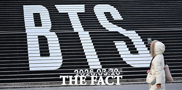 방탄소년단(BTS)의 5집 로고 조형물 살펴보는 관광객.