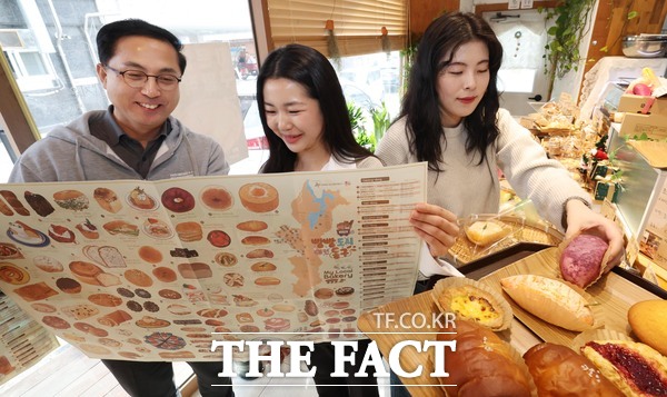 박희조 구청장과 동구 관계자들이 마을 빵집 영문지도 Bread City Donggu를 살펴보고 있다. /대전시 동구