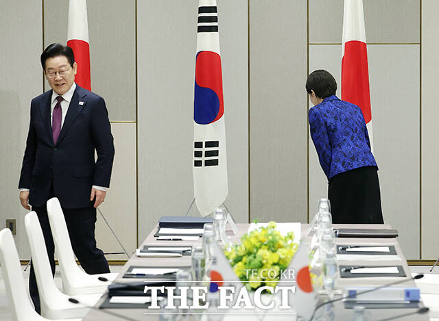 다카이치 사나에 총리가 이재명 대통령과 한일 확대 정상회담에서 기념촬영을 마친 뒤 태극기를 향해 예를 표하고 있다.