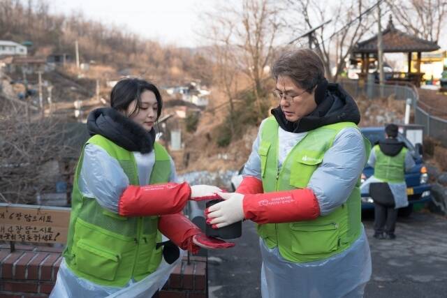 프로미봉사단원(왼쪽)과 정종표 DB손해보험 사장이 연탄 나눔 봉사활동을 진행하고 있다. /DB손해보험