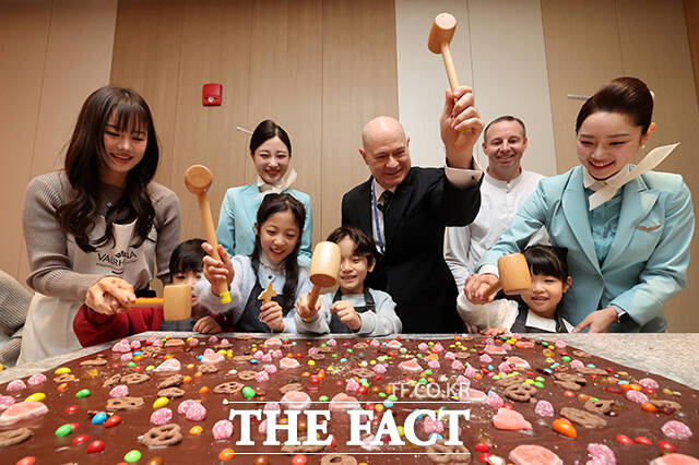 13일 인천국제공항 제2여객터미널 리뉴얼을 마친 대한항공 프레스티지 동편 좌측 라운지에서 데이비드 페이시 부사장(가운데)을 비롯한 관계자가 쿠킹 스튜디오 라이브러리에서 초콜릿을 부수고 있다. /인천국제공항=남윤호 기자