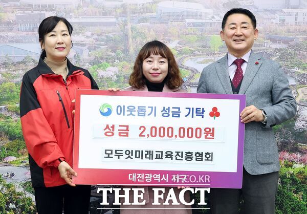 박경옥 모두잇미래교육진흥협회 회장(사진 가운데)이 12일 이웃돕기 성금 200만 원을 대전시 서구에 기탁하고 있다. /대전시 서구