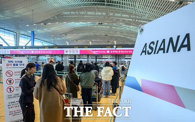 아시아나항공이 인천국제공항 제2터미널로 이전 운항을 개시한 14일 인천국제공항 2터미널 아시아나항공 체크인 카운터에서 승객들이 탑승 수속을 위해 줄을 서고 있다. /인천국제공항=남윤호 기자